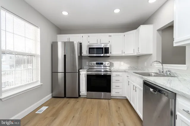 a kitchen with stainless steel appliances granite countertop a stove a sink and a refrigerator