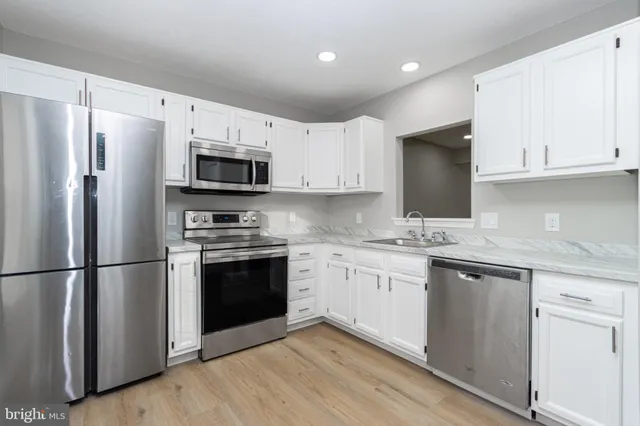 a kitchen with cabinets stainless steel appliances and a sink