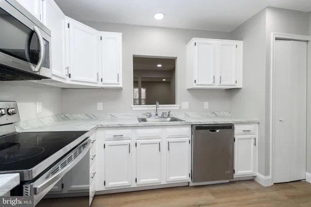 a kitchen with stainless steel appliances granite countertop a sink and a stove