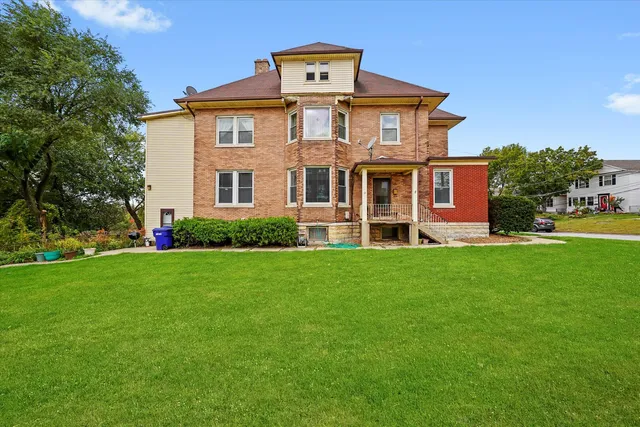 a view of a house with a yard and sitting area