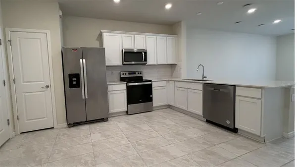 a kitchen with stainless steel appliances granite countertop a refrigerator and a sink