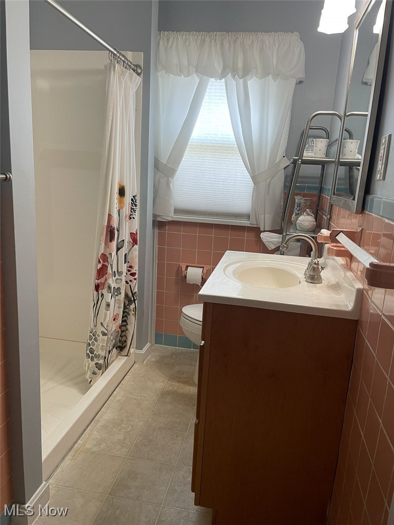 4425 2nd Street Northwest Canton, OH 44708 - Photo 15 of 24 Full bath with vanity, a stall shower, and tile walls