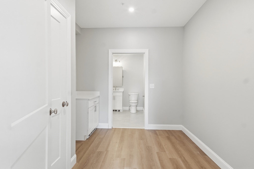 8 Vine Street, Unit 2 Haverhill, MA 01830 - Photo 15 of 20 an empty room with wooden floor and mirror