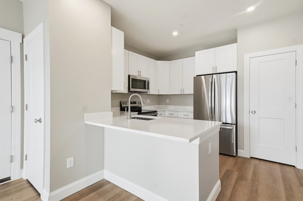 8 Vine Street, Unit 2 Haverhill, MA 01830 - Photo 2 of 20 a kitchen with a refrigerator a stove top oven a sink and dishwasher