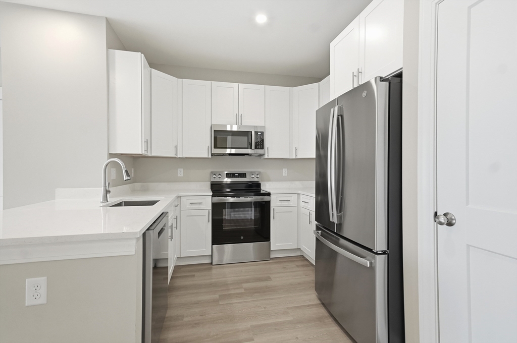 8 Vine Street, Unit 2 Haverhill, MA 01830 - Photo 3 of 20 a kitchen with a refrigerator sink and stainless steel appliances