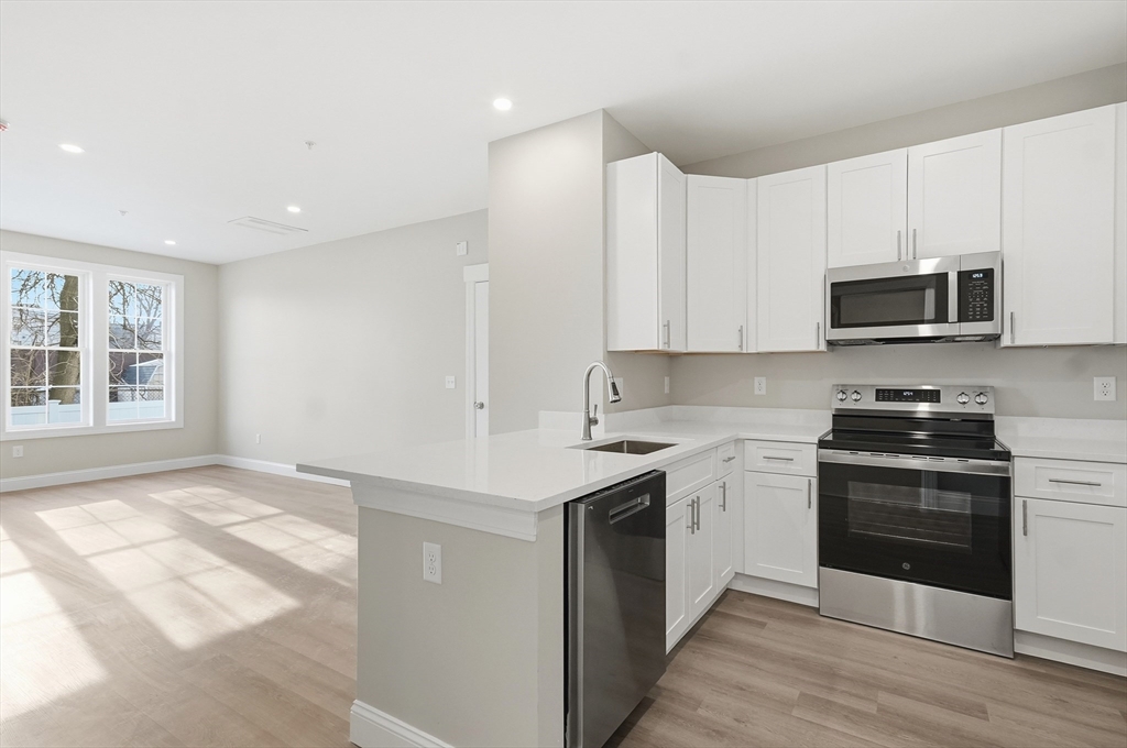 8 Vine Street, Unit 2 Haverhill, MA 01830 - Photo 4 of 20 a kitchen with stainless steel appliances granite countertop a stove a sink and a microwave