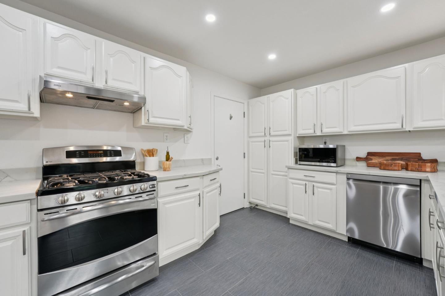 3336 Spring Street Redwood City, CA 94063 - Photo 14 of 40 a kitchen with granite countertop white cabinets and stainless steel appliances