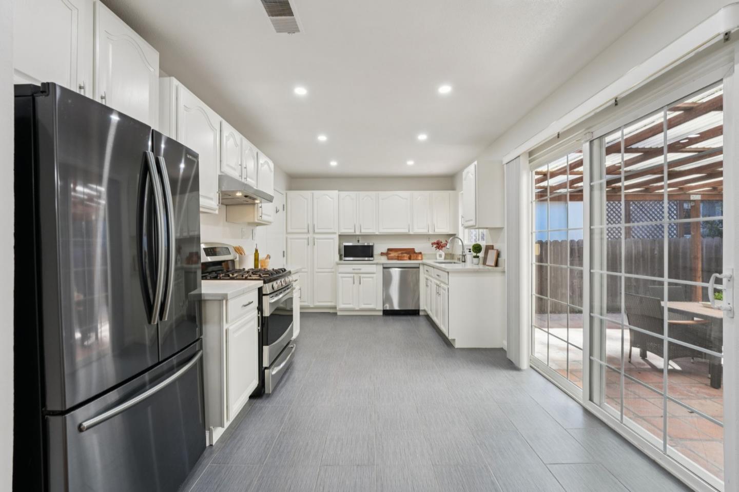 3336 Spring Street Redwood City, CA 94063 - Photo 20 of 40 a kitchen with refrigerator a sink and cabinets