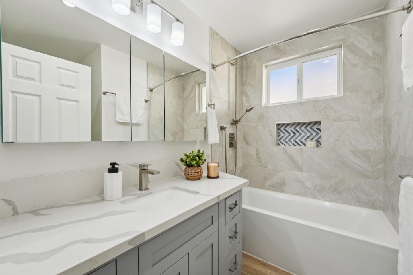 3336 Spring Street Redwood City, CA 94063 - Photo 21 of 40 a bathroom with a granite countertop sink a mirror a bathtub and shower