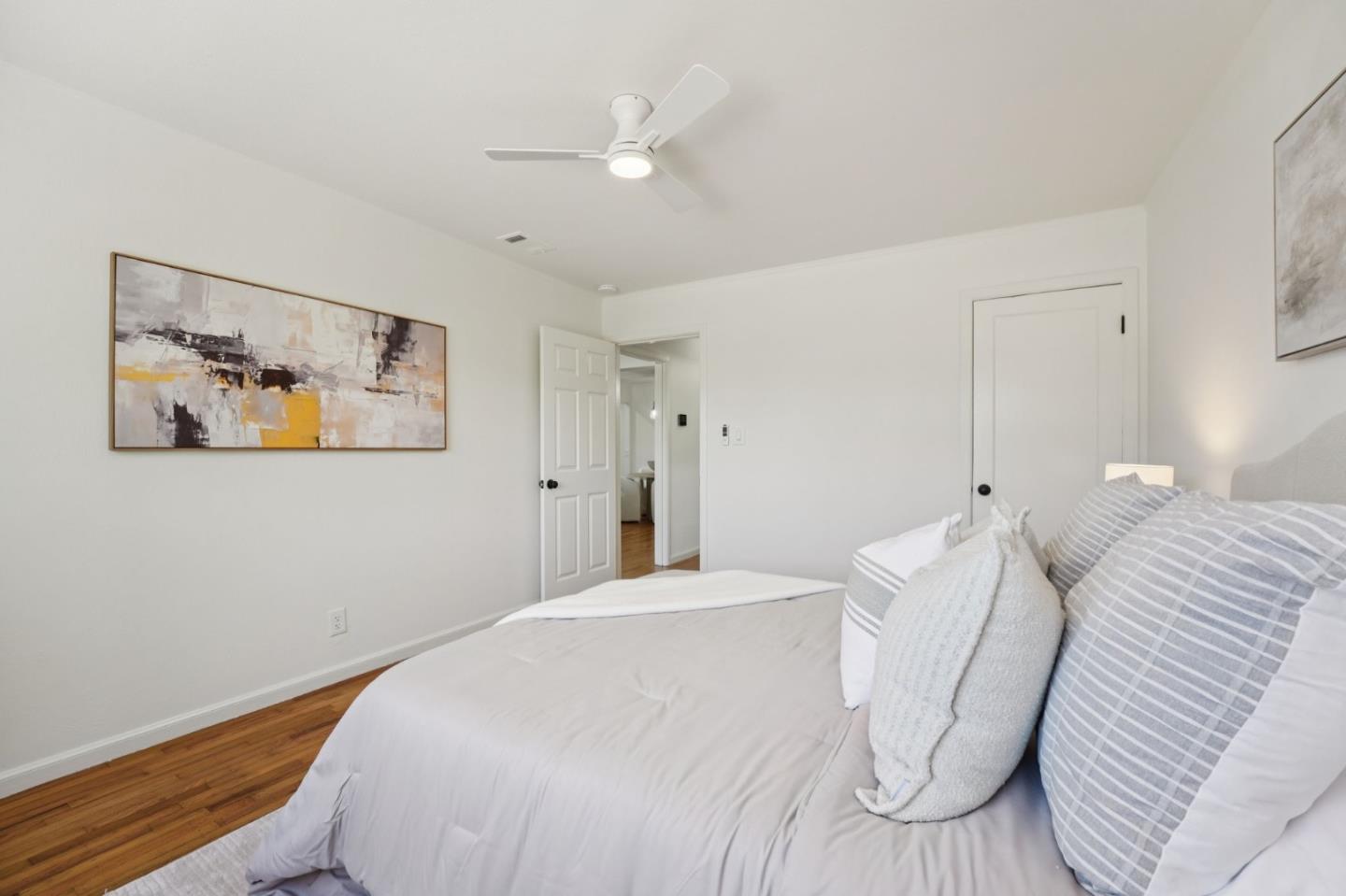 3336 Spring Street Redwood City, CA 94063 - Photo 24 of 40 a bedroom with a large bed and a chandelier