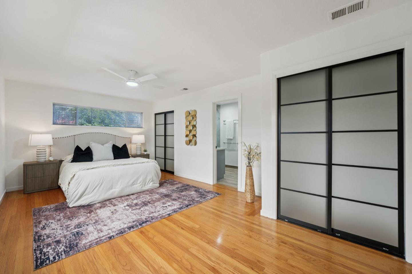 3336 Spring Street Redwood City, CA 94063 - Photo 32 of 40 a large bedroom with a bed and wooden floor