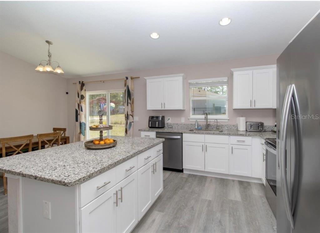 14 Hemlock Loop Court Ocala, FL 34472 - Photo 11 of 27 a kitchen with granite countertop cabinets and refrigerator