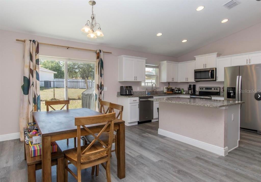 14 Hemlock Loop Court Ocala, FL 34472 - Photo 13 of 27 a kitchen with kitchen island a dining table and chairs