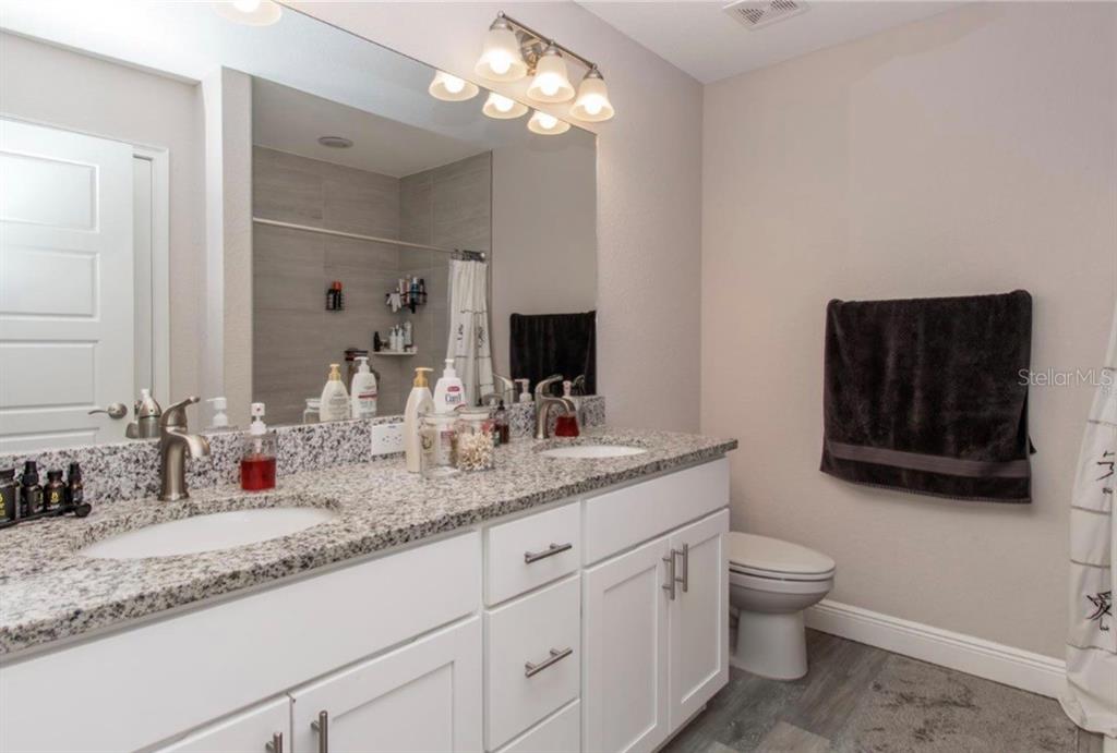 14 Hemlock Loop Court Ocala, FL 34472 - Photo 23 of 27 a bathroom with a granite countertop sink a toilet and mirror