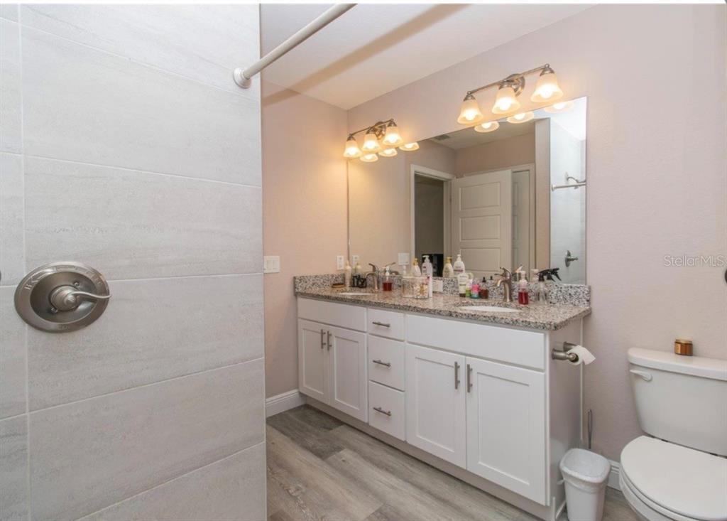 14 Hemlock Loop Court Ocala, FL 34472 - Photo 25 of 27 a bathroom with a granite countertop sink a toilet and a mirror