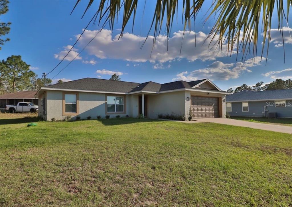 14 Hemlock Loop Court Ocala, FL 34472 - Photo 3 of 27 a front view of a house with a garden