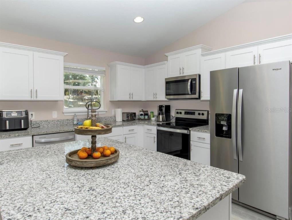 14 Hemlock Loop Court Ocala, FL 34472 - Photo 8 of 27 a kitchen with a sink a refrigerator and a stove top oven