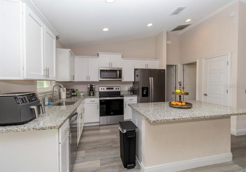 14 Hemlock Loop Court Ocala, FL 34472 - Photo 9 of 27 a kitchen with stainless steel appliances granite countertop a sink a stove and a refrigerator