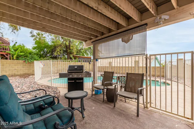 a view of a chairs and table in patio with wooden fence