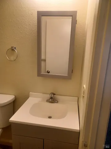 a bathroom with a sink a toilet and a mirror