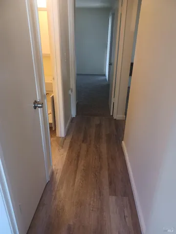 a view of a hallway with wooden floor and staircase