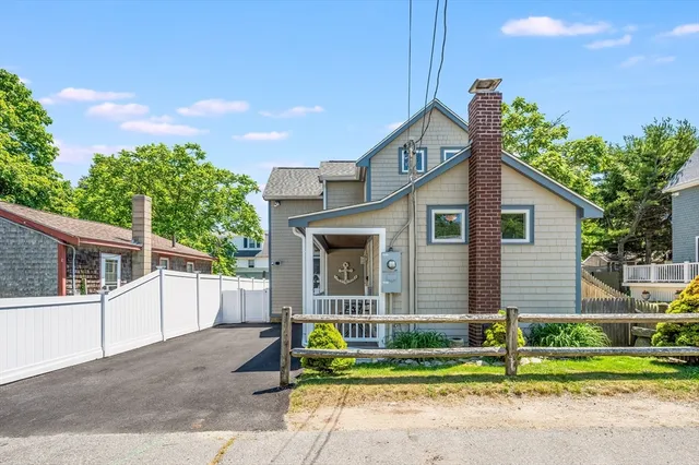 a front view of a house with a garden and plants