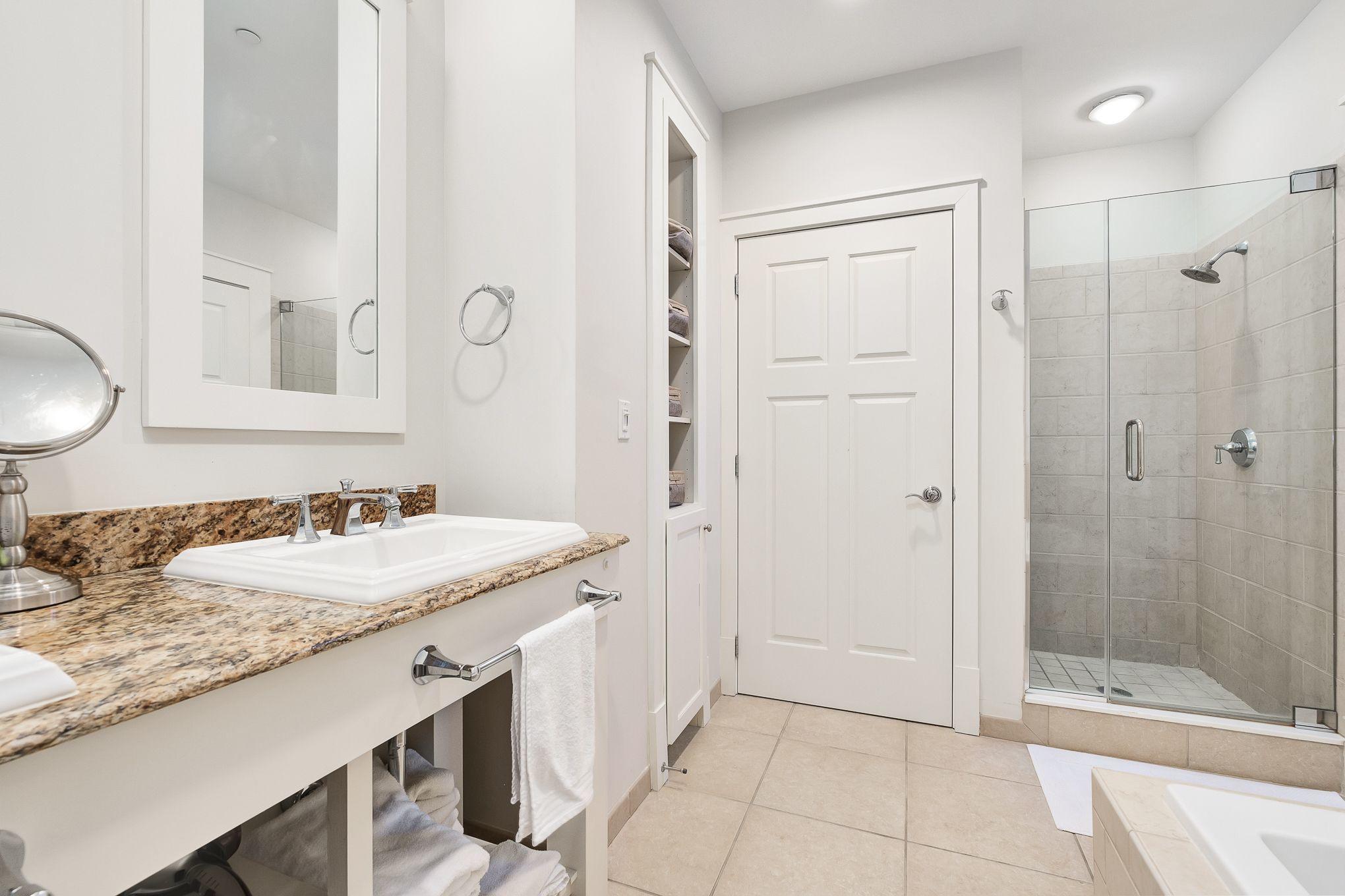 99 Compass Point Way South, Unit 406 Watersound, FL 32461 - Photo 16 of 41 a bathroom with a granite countertop sink mirror and shower