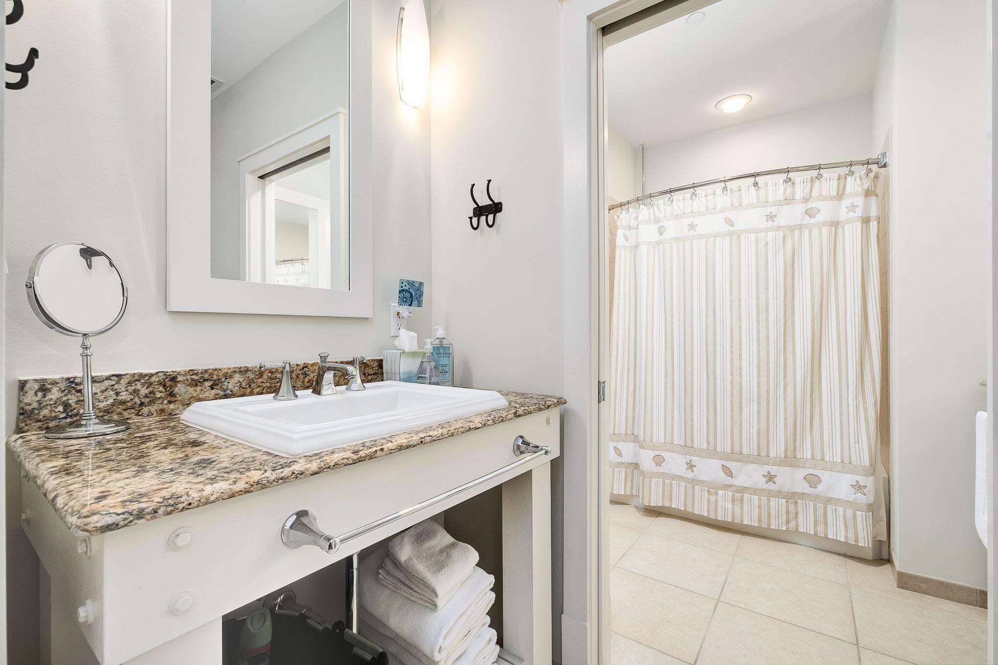 99 Compass Point Way South, Unit 406 Watersound, FL 32461 - Photo 22 of 41 a bathroom with a granite countertop sink and a mirror