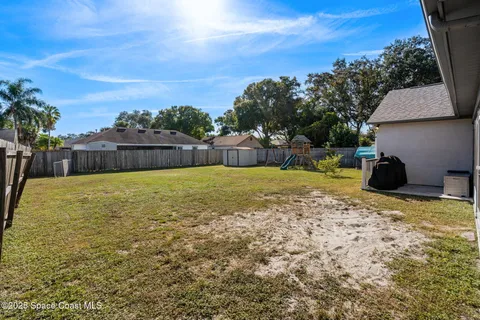 a swimming pool that has lawn chairs and a dining table under an umbrella