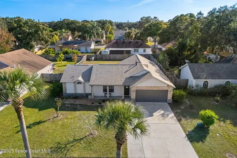an aerial view of a house with swimming pool and a yard