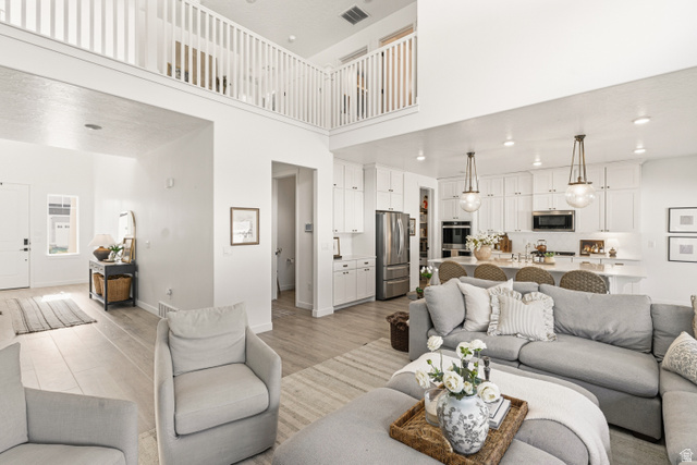 870 North Ada Loop Lehi, UT 84048 - Photo 8 of 51 Open-concept living space featuring high ceilings, wood-finish flooring, a white-balustrade overlook, and recessed lighting