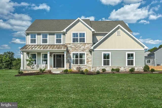 a front view of a house with garden and trees