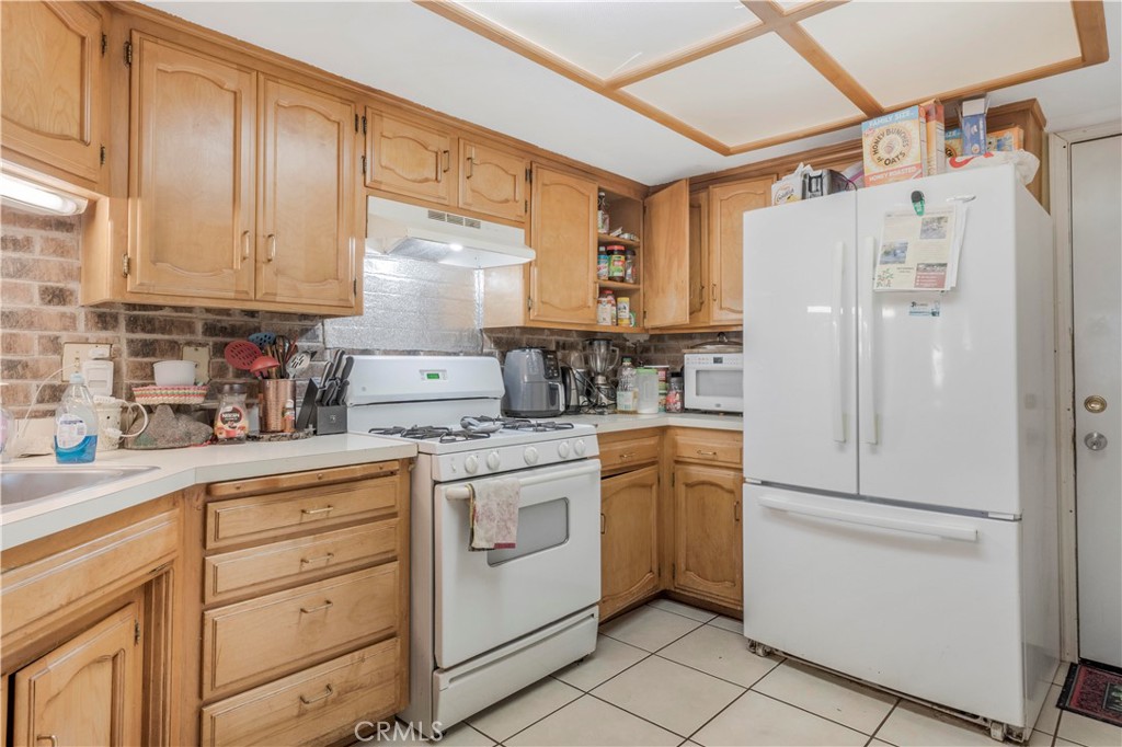 240 North 4th Street Shandon, CA 93461 - Photo 14 of 38 a kitchen with white cabinets and white appliances