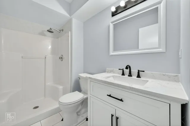 a view of a white house with a big yard and potted plants