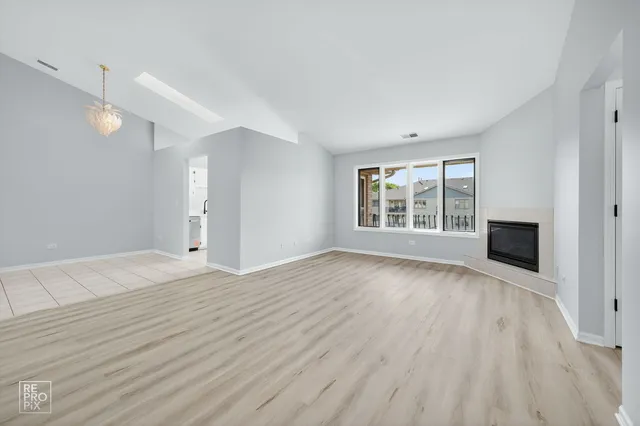 a view of empty room with wooden floor and entryway