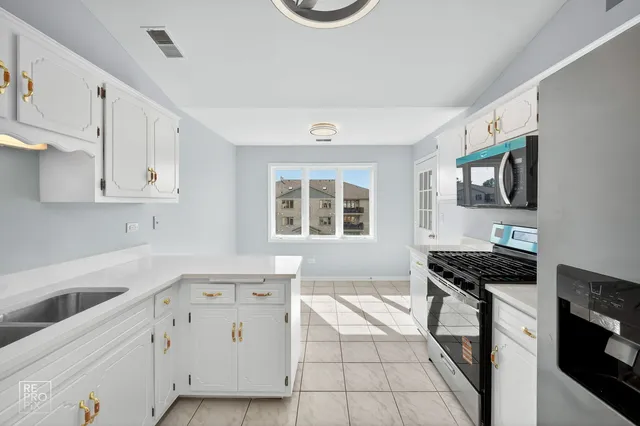 a kitchen with stainless steel appliances a stove a sink and a refrigerator