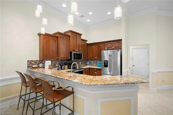 a view of a dining room and kitchen with furniture a chandelier and kitchen view