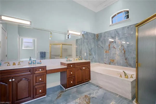 a spacious bathroom with a bathtub a sink and a mirror