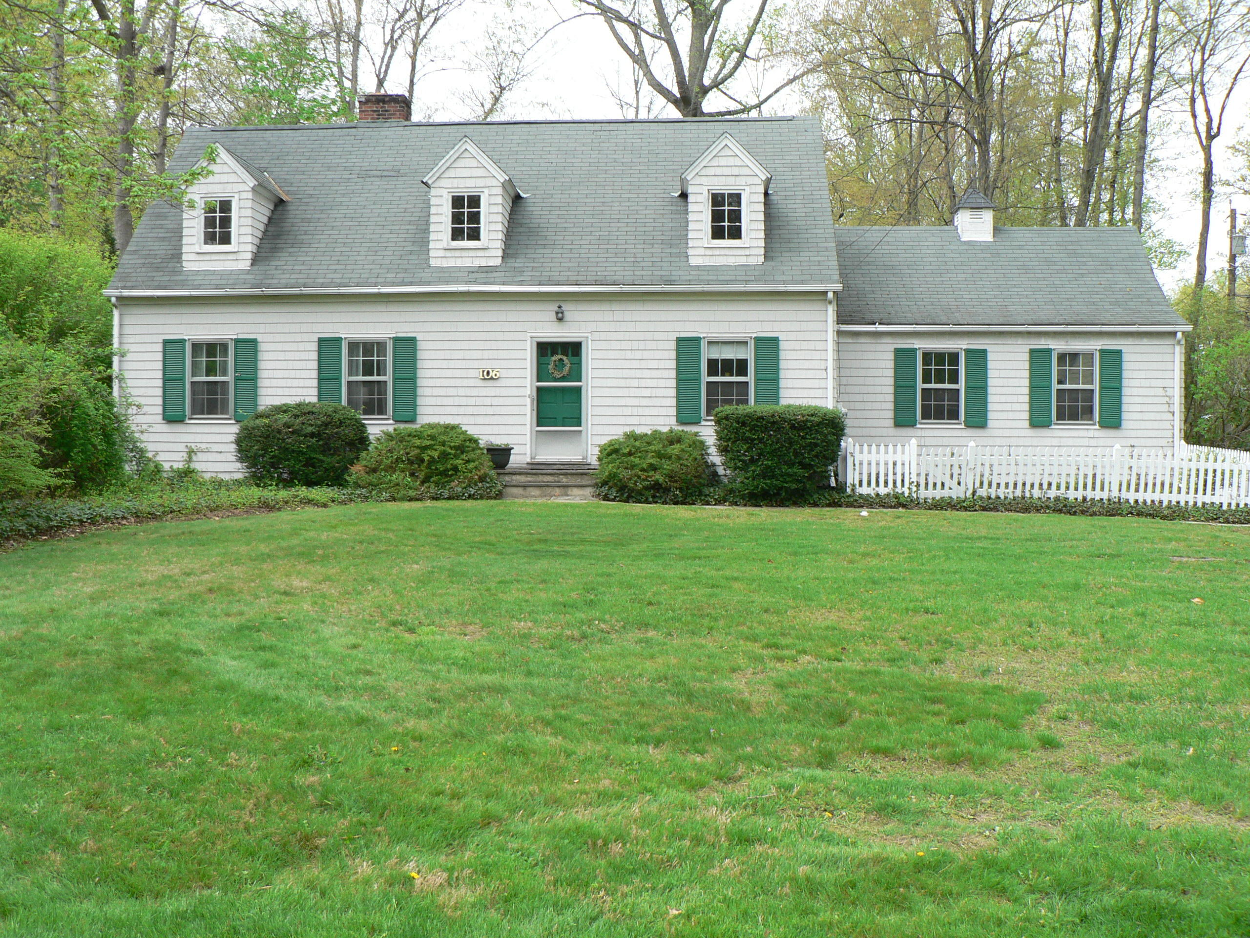 106 Woodland Road New Canaan, CT 06840 - Photo 1 of 10 a front view of house with yard and green space