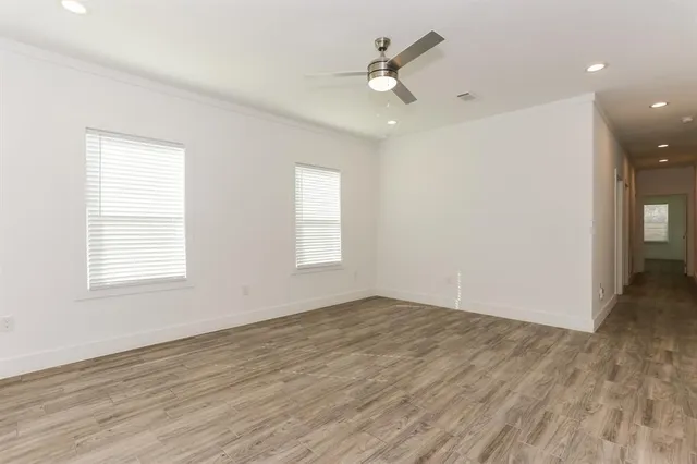 an empty room with wooden floor and window