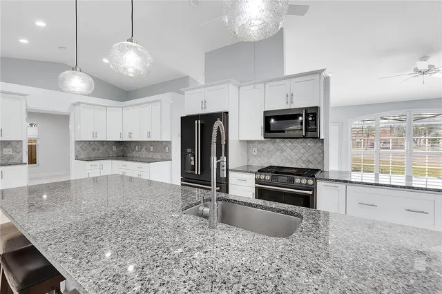a kitchen with kitchen island a sink stainless steel appliances and cabinets