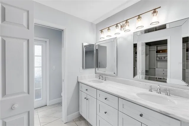 a bathroom with double vanity sink and a mirror