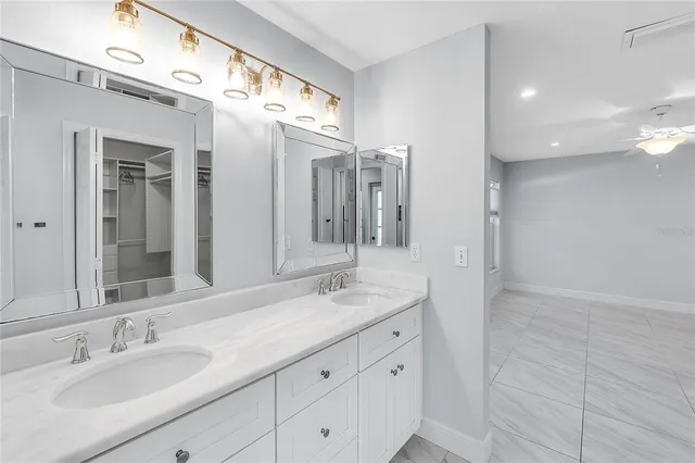 a bathroom with a granite countertop double vanity sink and mirror