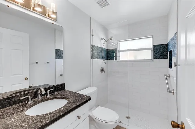 an empty room with wooden floor and chandelier fan