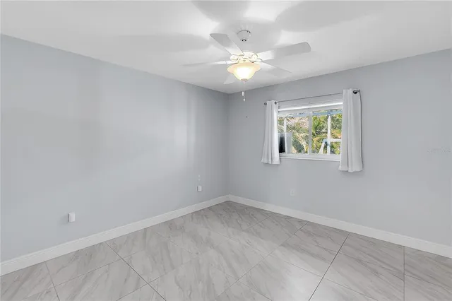 an empty room with fan and entrance