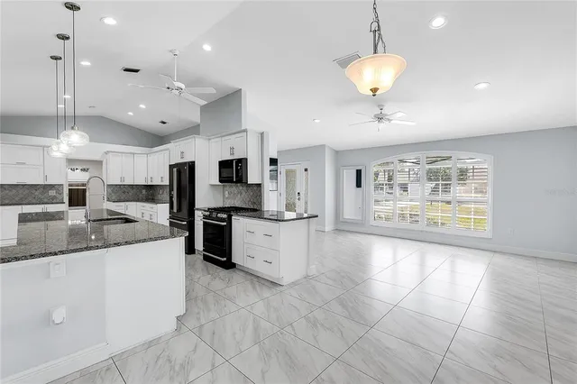 a large kitchen with a large counter top appliances and cabinets