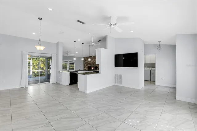 a view of a kitchen with kitchen island stainless steel appliances wooden floor and window