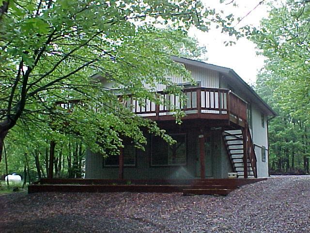 4 Fern Ridge Road Blakeslee, PA 18610 - Photo 3 of 4 a view of a house with large tree plants and wooden fence