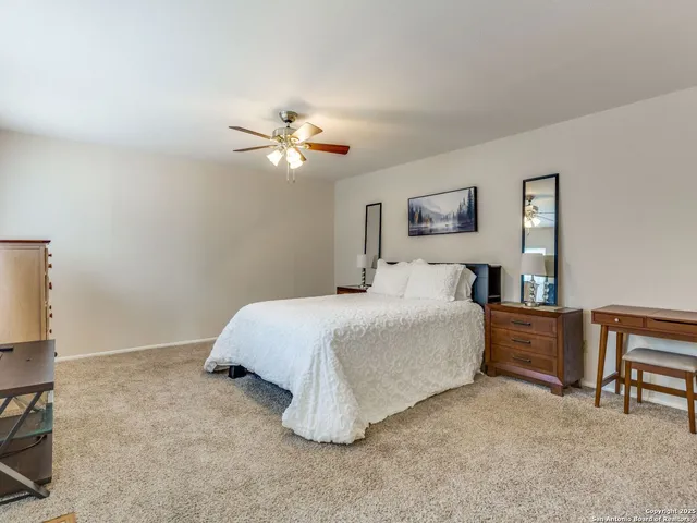 a spacious bedroom with a bed and a chandelier