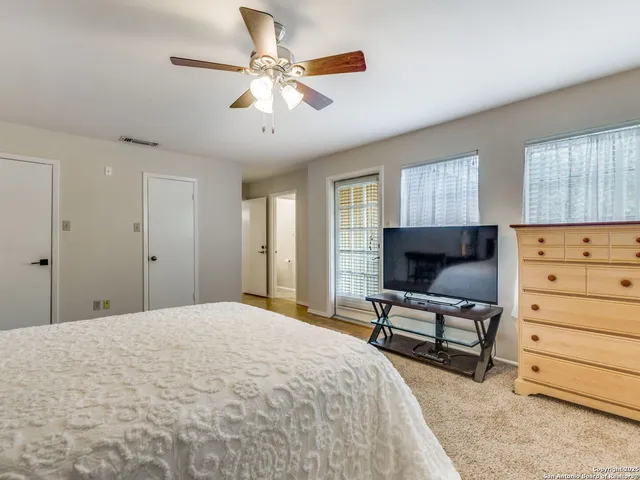 a bedroom with a bed a dresser and window